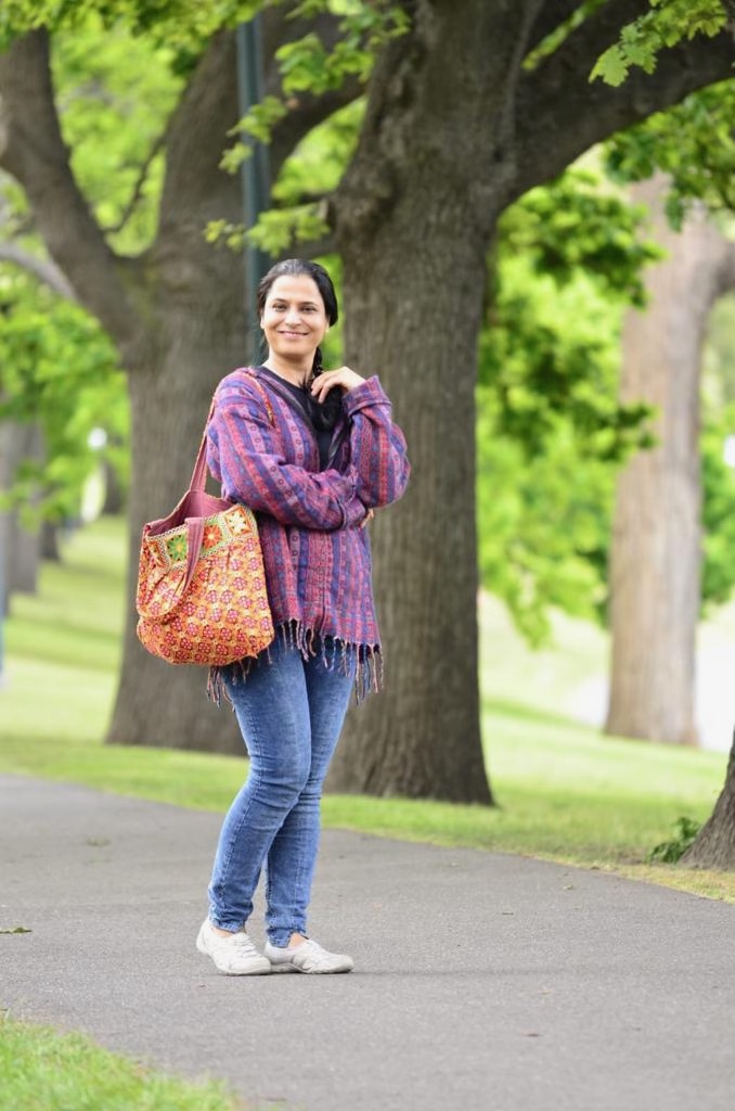 Sindhu Sivadas smiling on a tree-lined Melbourne path